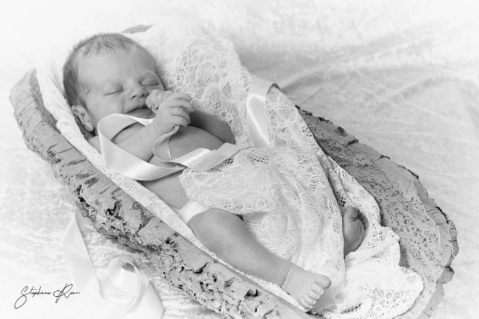 Un bébé bien calme Bébé dans son berceau d'écorce